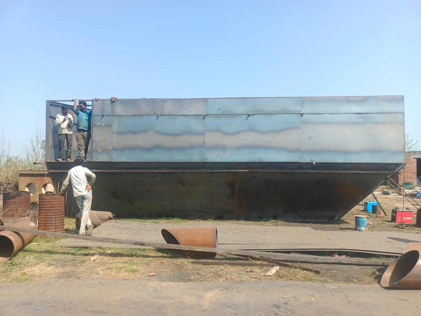 Heavy steel plate being rolled into a cylindrical shell section