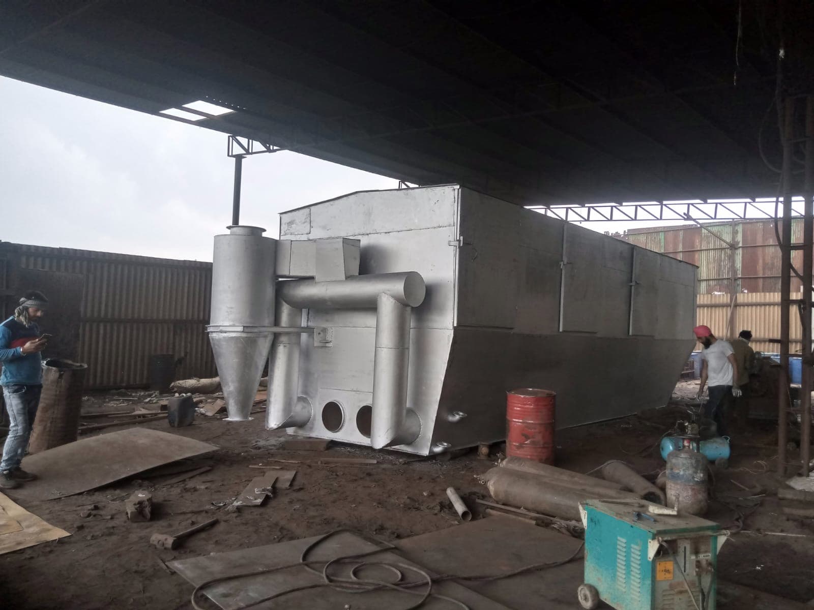 Heavy steel plate being rolled into a cylindrical shell section